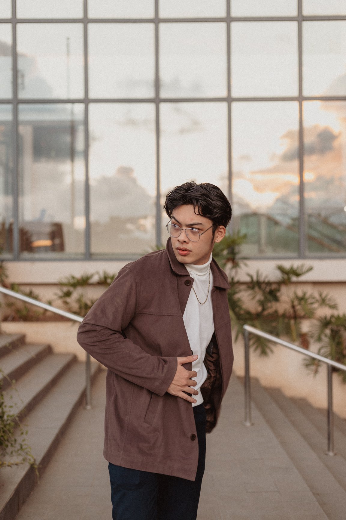 Young Man in Brown Jacket Standing on the Stairs Outdoors